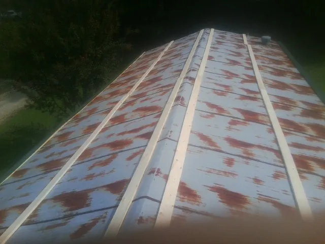 Rusted metal roof panels with new wood purlins before replacement — Storm Damage Roof Repair in Winchester by Roofing Brothers